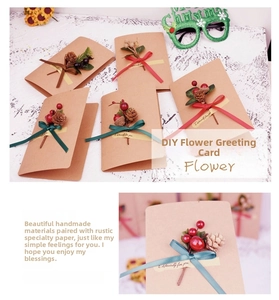 Close-up of DIY Christmas greeting card with pine cones, berries, and brown kraft paper