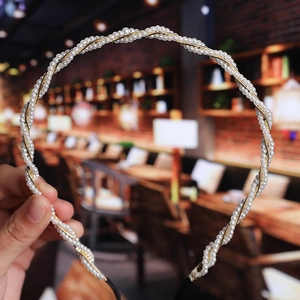 Macro shot of layered pearl headband with gold metal wire details on minimalist design