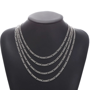 Detail of multi-layered silver chain necklace on a black mannequin display stand