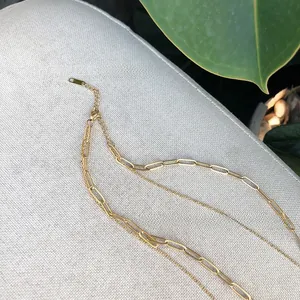 Detail of double-layer gold chain necklace with paperclip links and lobster clasp