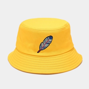 Detailed close-up of feather embroidery on a yellow canvas bucket hat with stitching