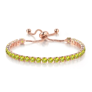 Detailed macro view of rose gold adjustable slider buckle and emerald green zirconia crystals
