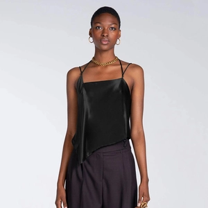 Detail view of black satin crop top with thin straps and smooth texture on model