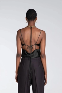 Close-up of the elegant crisscross back lace-up detail on this black satin crop top