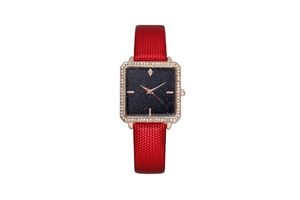 Detail of square rose gold watch with sparkling starry dial and red textured strap