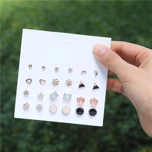Close-up of 12-pair gold and silver plated stud earring set with zircons on display card