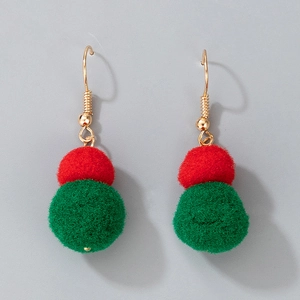 Detail of festive Christmas earrings featuring red and green plush pom-poms on gold hooks