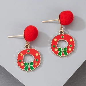 Close-up of festive Christmas wreath earrings with red pom-poms and green ribbon bow