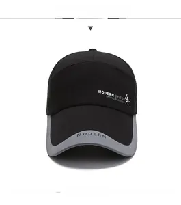 Detail of black baseball cap with Modern British text and long brim for sun protection
