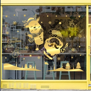 Golden Christmas window stickers featuring Santa Claus and reindeer on glass storefront