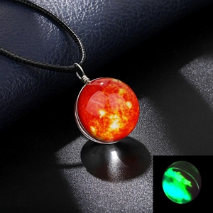 Detail of galaxy glass ball necklace with glowing sun pattern and luminous effect in the dark