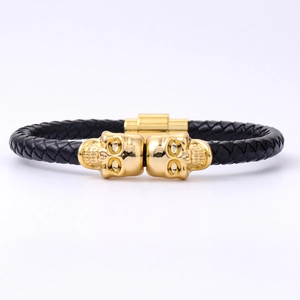 Men's black braided leather punk bracelet with double gold skull charms and magnetic clasp