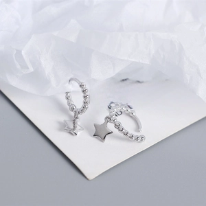 Macro detail of S925 sterling silver hoop earrings with beads and star charms