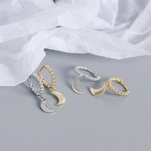 Primo piano di orecchini a cerchio con luna in argento 925 minimalisti in oro e argento