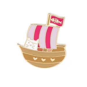 Detailopname van een roze emaille pin: piratenschip met een kat en een visgraatvlag