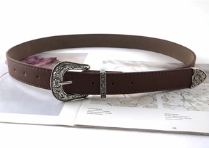 Detail of brown leather western belt set with silver engraved buckle and metal tip