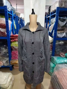 Detail view of grey long-sleeve knit cardigan with cable pattern and front pockets