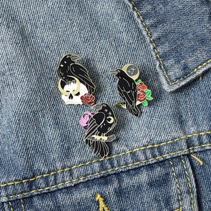 Gothic black crow enamel brooch set featuring skull, moon, and rose on denim jacket