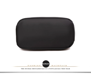 Detailed bottom view of black mini backpack showing durable reinforced stitching