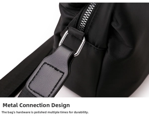 Detail of silver zipper and reinforced stitching on black nylon crossbody phone bag