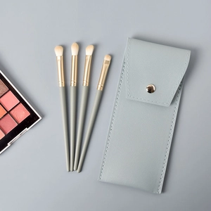 Détail de 4 pinceaux à paupières avec manches gris Morandi et pochette en cuir assortie