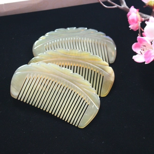 Macro detail of three crescent yak horn combs with leaf engravings on black velvet
