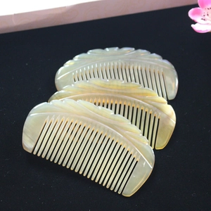 Macro detail of three carved ox horn combs with natural patterns on black velvet