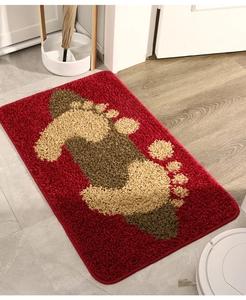 Detail of red plush absorbent doormat with beige footprint pattern in home entrance