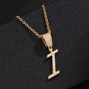 Close-up of golden letter I pendant featuring shimmering micro-paved cubic zirconia stones