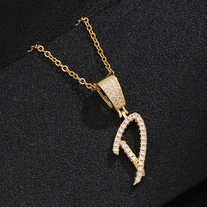 Macro detail of 18K gold letter D pendant necklace featuring sparkling white zircon pave