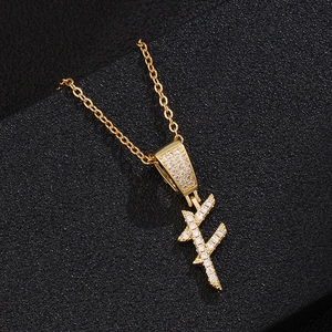 Close-up of golden zircon initial pendant necklace on a premium black textured display