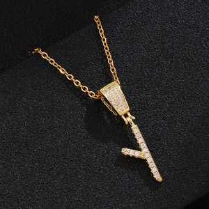 Detail of gold letter Y pendant necklace with micro-pave crystals on black background