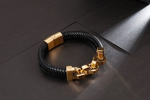 Detail of black braided leather bracelet with gold stainless steel magnetic buckle