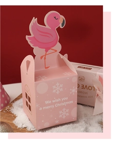 Pink Christmas apple gift box with flamingo-shaped cutout on a snowy festive background