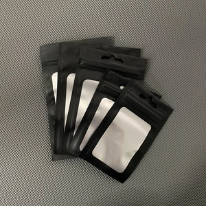 Detail view of five matte black and silver aluminum foil zip lock bags with hanging holes