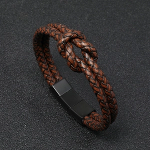 Detail of a brown braided leather bracelet with a black stainless steel magnetic clasp
