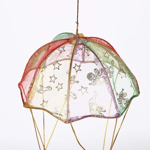 Close-up of colorful mesh parachute ornament with golden angel and star patterns