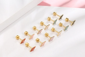 Macro detail of colorful enamel square stud earrings with gold star and screw back design