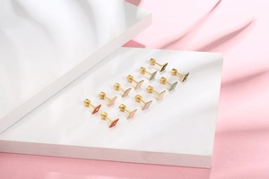 Macro shot of colorful square enamel stud earrings with gold star and screw back