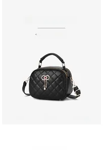 Close-up of black quilted PU leather crossbody bag with bow charm and chain strap