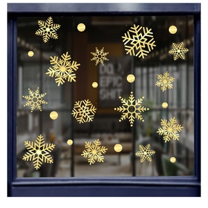 Detailed view of gold snowflake window stickers with a metallic finish on glass