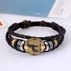 Detail view of woven brown leather Capricorn zodiac bracelet with bronze hardware charm