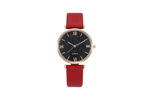 Close-up of starry black dial with rose gold Roman numerals and red leather strap