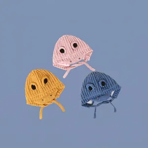 Knitted baby dinosaur earflap hats in pink, yellow, and blue with chin straps