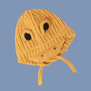 Detail of yellow knit dinosaur baby hat showing earflaps and soft woolen texture
