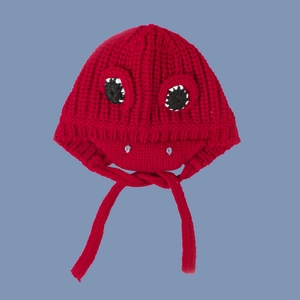 Close-up of red dinosaur knit baby hat with cartoon eyes and chin straps for winter warmth