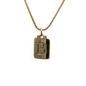 Close-up of golden rectangular letter B pendant with elegant box chain necklace