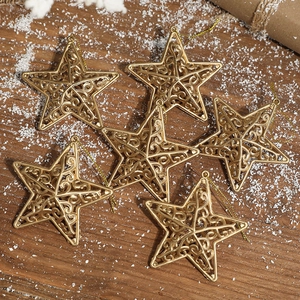 Set of six hollow gold star ornaments for Christmas tree hanging on wooden background
