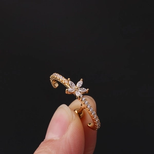 Close-up of gold flower zircon cartilage earring with sparkling crystal details