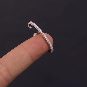 Long bar screw earring in stainless steel with sparkling cubic zirconia on a fingertip
